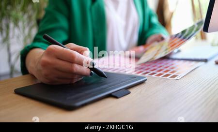 Interior designer working with fan of colourful samples and using grapgic tablet Stock Photo