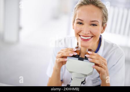 Im confident Ill find a cure. a beautiful woman in a laboratory working with a microscope. Stock Photo