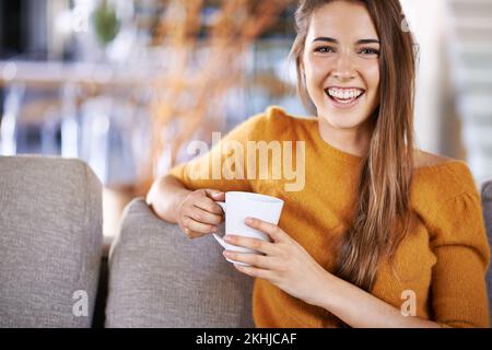 Coffee and leisure. Cropped image of a pretty young female drinking coffee while sitting on the sofa. Stock Photo