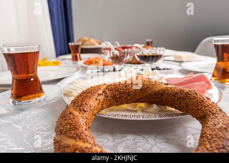 Simit, delicious breakfast table with close up Turkish bagel called simit. Selective focus, blurred traditional table setup. Home food concept idea. Stock Photo