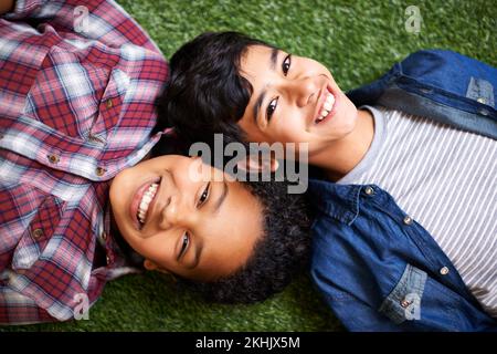 Brother sister bonding time. a brother and sister lying together on the grass. Stock Photo