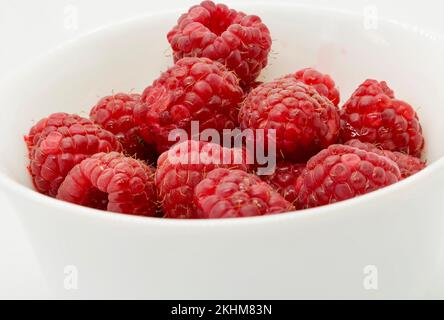 Macro of red raspberries on white bawl Stock Photo