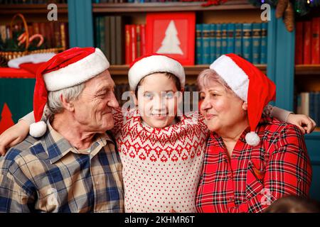 Excited grandchild greeting grandparents visiting on Christmas day. Stock Photo