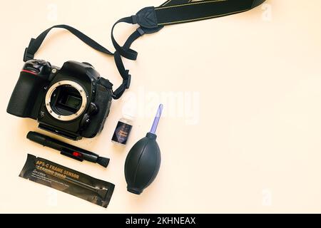 Top view close up camera sensor and lens cleaning tools with dslr camera on white background. Selective focus. Brush, blower, camera, swab, liquid tub Stock Photo