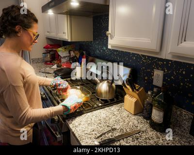 Candid shot of young woman preparing food for holiday dinner at home. Fishers, IN. November 2022. Stock Photo