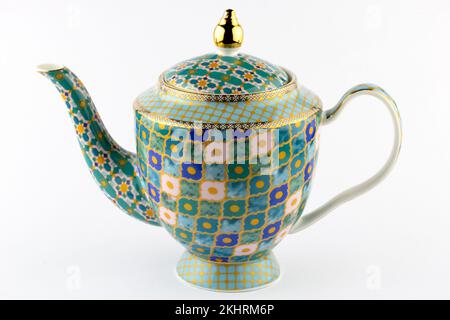 Porcelain teapot with gold and blue, green patterns isolated on white Stock Photo