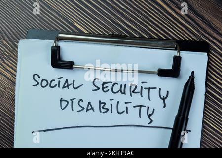 Concept of Social Security Disability write on paperwork isolated on Wooden Table. Stock Photo