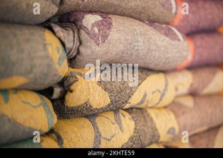 Samples of linen fabrics in a pile on store shelf. Stock Photo