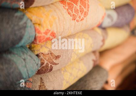 Samples of linen fabrics in a pile on store shelf. Stock Photo