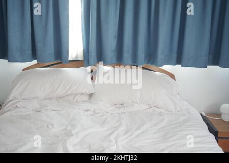 messy white color bed in early morning , messy bed after waking up  Stock Photo