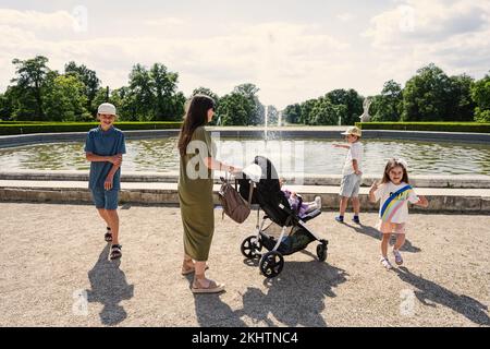 Mother with kids near fountain of Slavkov Castle, also known as Austerlitz Castle, is a Baroque palace in Slavkov u Brna, Czech Republic Stock Photo