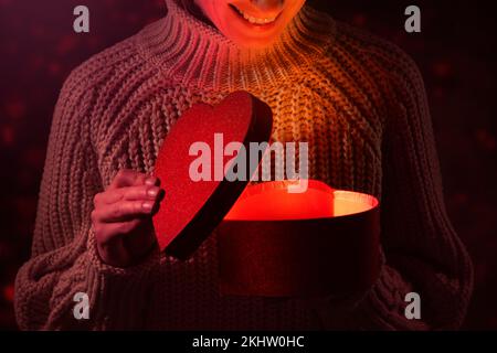 woman open a heart shaped gift box. romantic anniversary or valentine's day present Stock Photo