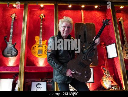 24 November 2022, Hamburg: Uli Salm, celebrity host and rock musician, shows the bass ' The Zwick Pö', made from a table top in the Zwick Pöseldorf, in the Zwick St. Pauli. Guitar maker Jens Ritter presents some of his instruments at the cult pub 'Zwick' in Hamburg-St. Pauli. Ritter's electric guitars and basses are purchased not only by musicians but also by collectors and museums; his instruments are also on display at the Metropolitan Museum of Art (New York) at the Smithsonian American Art Museum (Washington, DC) and at the Technoseum (Mannheim). Photo: Marcus Brandt/dpa Stock Photo