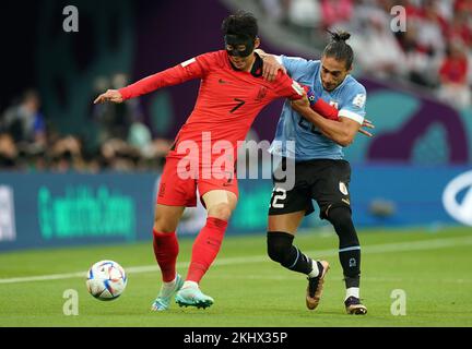 South Korea's Son Heung-min (left) and Uruguay's Martin Caceres battle for the ball during the FIFA World Cup Group H match at the Education City Stadium, Doha, Qatar. Picture date: Thursday November 24, 2022. Stock Photo