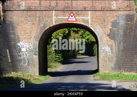 A railway bridge with limited headroom over a narrow country lane. Stock Photo