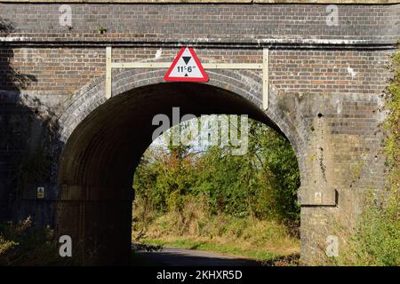 A railway bridge with limited headroom over a narrow country lane. Stock Photo