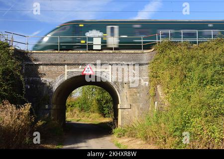 A railway bridge with limited headroom over a narrow country lane. Stock Photo