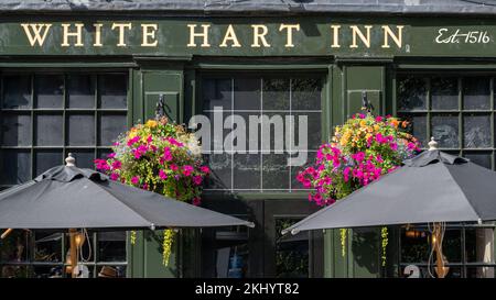 Colourful flower baskets hang outside the 16th century White Hart Inn, in Edinburgh's historic Grassmarket. Stock Photo