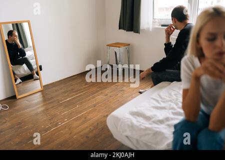 Unhappy thoughtful married couple not talking after dispute, troubled with unwilling pregnancy. Pensive sad woman feeling guilty Stock Photo