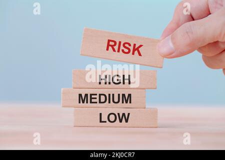 Hand holding chooses wooden block cubes with risk word. Risk management concept. Stock Photo