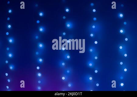 Christmas blue bokeh from garland neon light. Bokeh lights. Beautiful Christmas background. Desfocused background. Copy space text. Concept Blurred blue Christmas decorations garlands lights bokeh Stock Photo