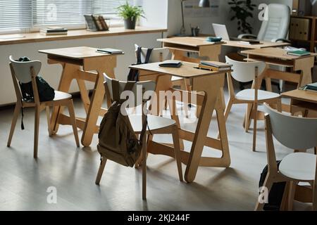 Modern empty classroom with wooden desks for students Stock Photo