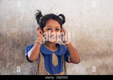 school girl holding onto his ears in classroom Stock Photo