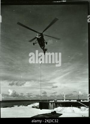 Project 26 - Operation Dominic (Johnston Island/Christmas Island/Maui, Hawaii) Test Activities. Helicopter delivers instrumentation to Johnston Island. Photographs of Atmospheric Nuclear Testing at Pacific Island and Nevada Test Sites. Stock Photo