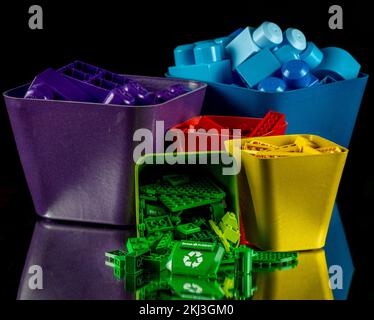 Various toy blocks and Legos sorted by color with a recycling sign Lego in front Stock Photo