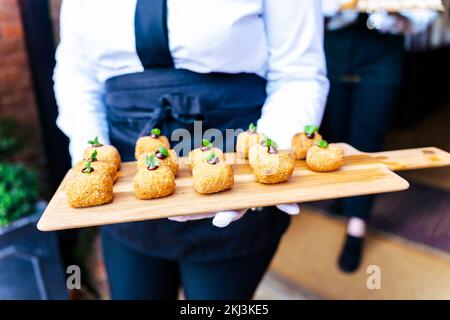 Wedding reception event party catering with appetisers and canapés being served by servers in the garden for their guests Stock Photo