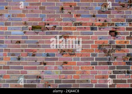 Background, brick wall made old German red burnt brick with traces bullets and shrapnel after World War II Stock Photo
