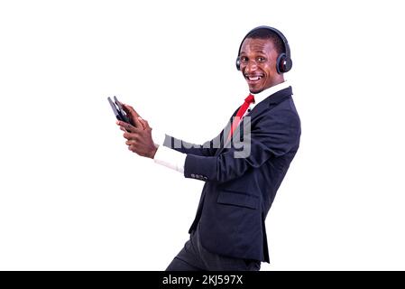 a businessman standing on a white background communicating using a headset and a tablet looking at the camera in profile, smiling. Stock Photo