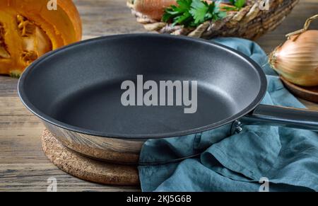 empty clean frying pan on wooden kitchen table Stock Photo