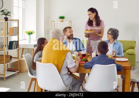 Happy multi-generational family is celebrating thanksgiving at festive table with delicious food. Stock Photo