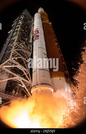 Flames from the solid rocket boosters light up the clouds of smoke and ...
