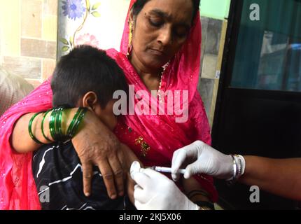 Mumbai, India. 24th Nov, 2022. A health worker administers a dose of measles vaccine to a child at a temporary vaccination camp in Mumbai, India, on Nov. 24, 2022. A measles outbreak has already been reported in Mumbai. Local media reports said since January this year, 220 cases of measles and 11 related deaths have been recorded in the city. Credit: Str/Xinhua/Alamy Live News Stock Photo