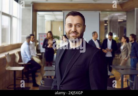 Happy business coach standing in office after professional corporate training class Stock Photo