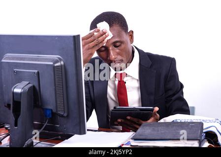 handsome adult businessman wiping his forehead with a handkerchief while working on a digital tablet. Stock Photo