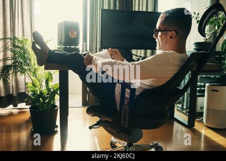Man reading book at home. Stock Photo