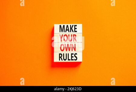 Make your own rules symbol. Concept words Make your own rules on wooden cubes. Beautiful orange table orange background. Business motivational make yo Stock Photo