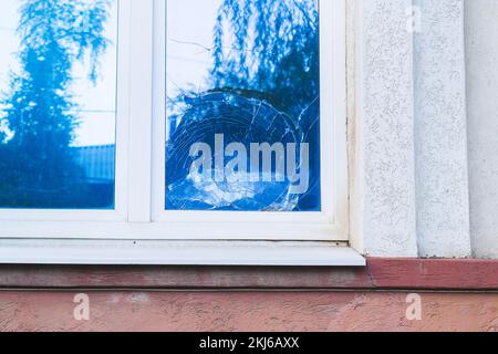 Broken glass in window. Shards of glass. Cracks in window glass after impact.. Stock Photo