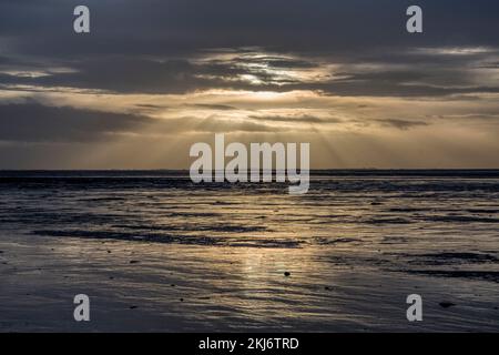 Sun breaking through the clouds over the Wash in late afternoon.  View to west from Snettisham beach, Norfolk. Stock Photo