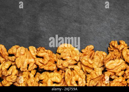 Walnuts. Walnut kernels on dark stone table. Top view Stock Photo