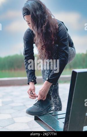 Sneakers. close up of a woman tying shoelaces. Women's sneaker ready for outdoor running in the park or forest. Stock Photo