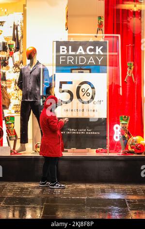 London, UK. 24th Nov, 2022. Shoppers walk past shop windows in Regent and Oxford Street, displaying their Black Friday Sales signs and discounts, ready for tomorrow's famous sales event. Credit: Imageplotter/Alamy Live News Stock Photo