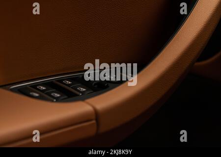 Close up view of button controlling window in modern car interior. Vehicle interior detail. Door handle with windows controls Stock Photo