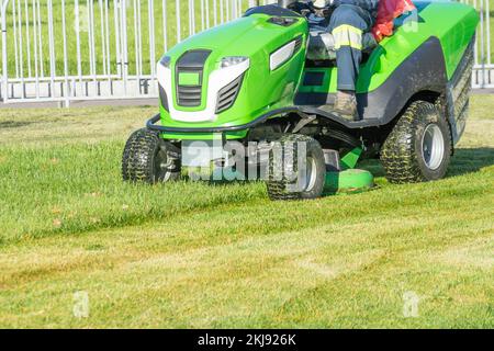Ride lawn mower mows a green fresh grass Stock Photo