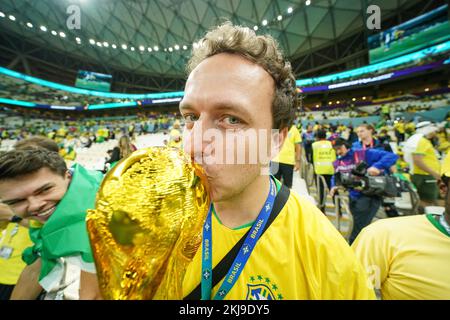 LUSAIL, QATAR - NOVEMBER 24: Supporter of Brazil kiss a world cup trophy replica before the FIFA World Cup Qatar 2022 group G match between Brazil and Serbia at Lusail Stadium on November 24, 2022 in Lusail, Qatar (Photo by Florencia Tan Jun/PxImages) Credit: Px Images/Alamy Live News Stock Photo