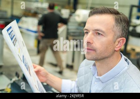 worker in a printing and press centar checking a document Stock Photo
