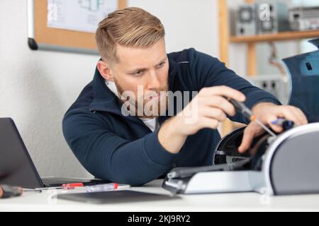 young man checking pinter in office Stock Photo